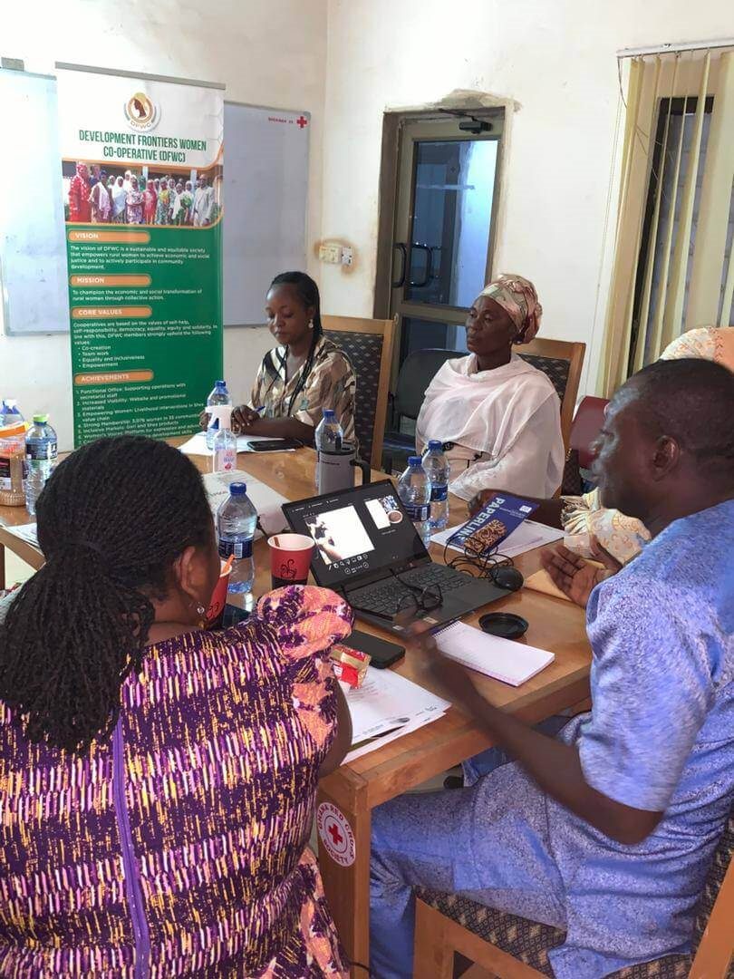 A meeting beside a Development Frontiers Women Cooperative banner