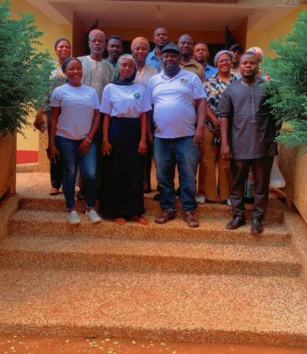 Development Frontiers staff and community stakeholders gathered on the steps of a development centre in Tamale