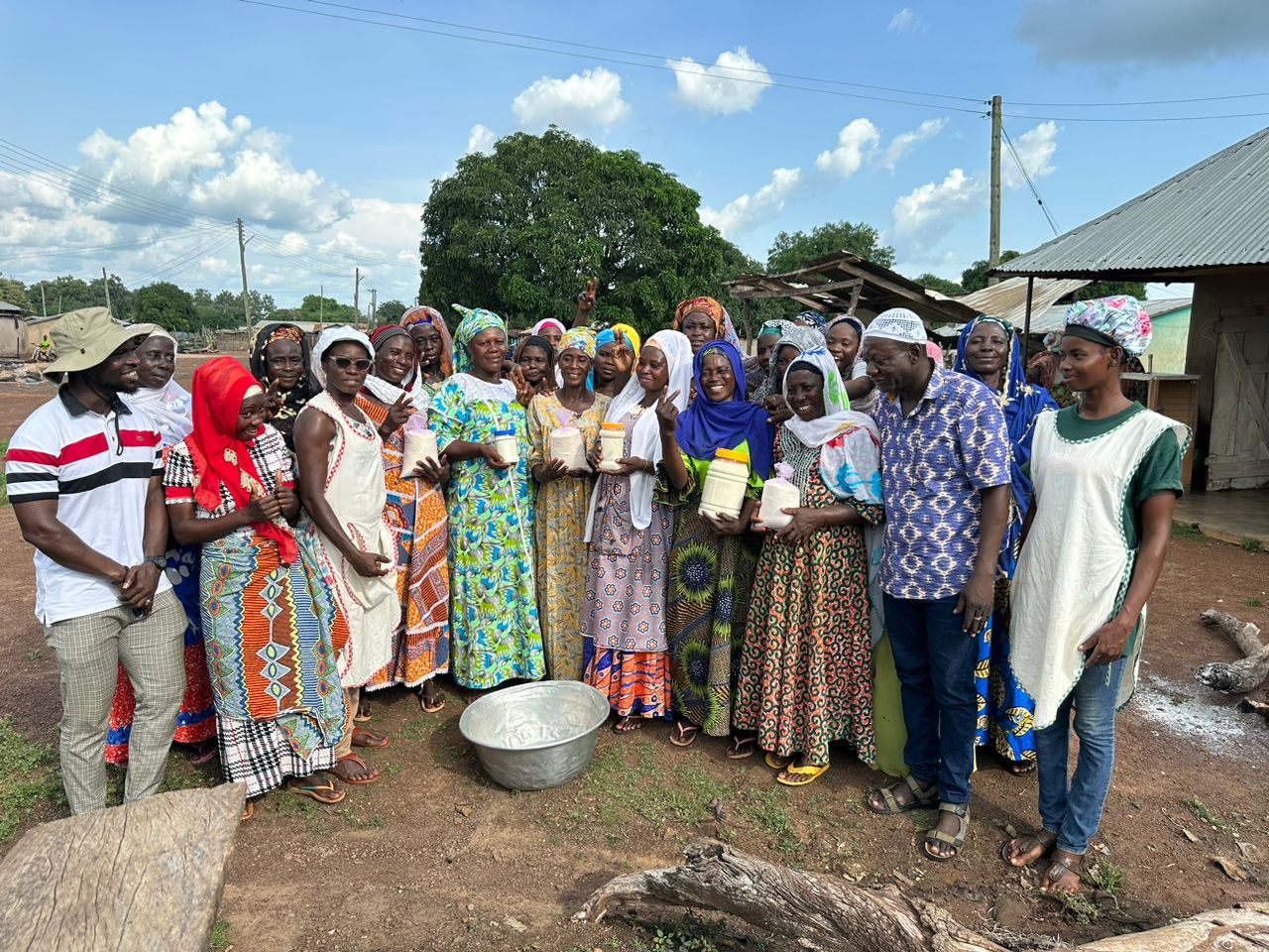 Women cooperative members holding jars of processed shea butter